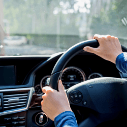 Hands on a steering wheel in a moving car during an intensive driving course