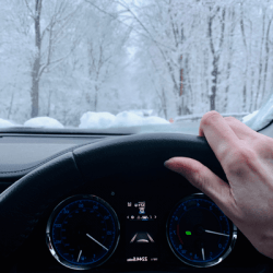 Dashboard and steering wheel of a car being driven in snow driving safety